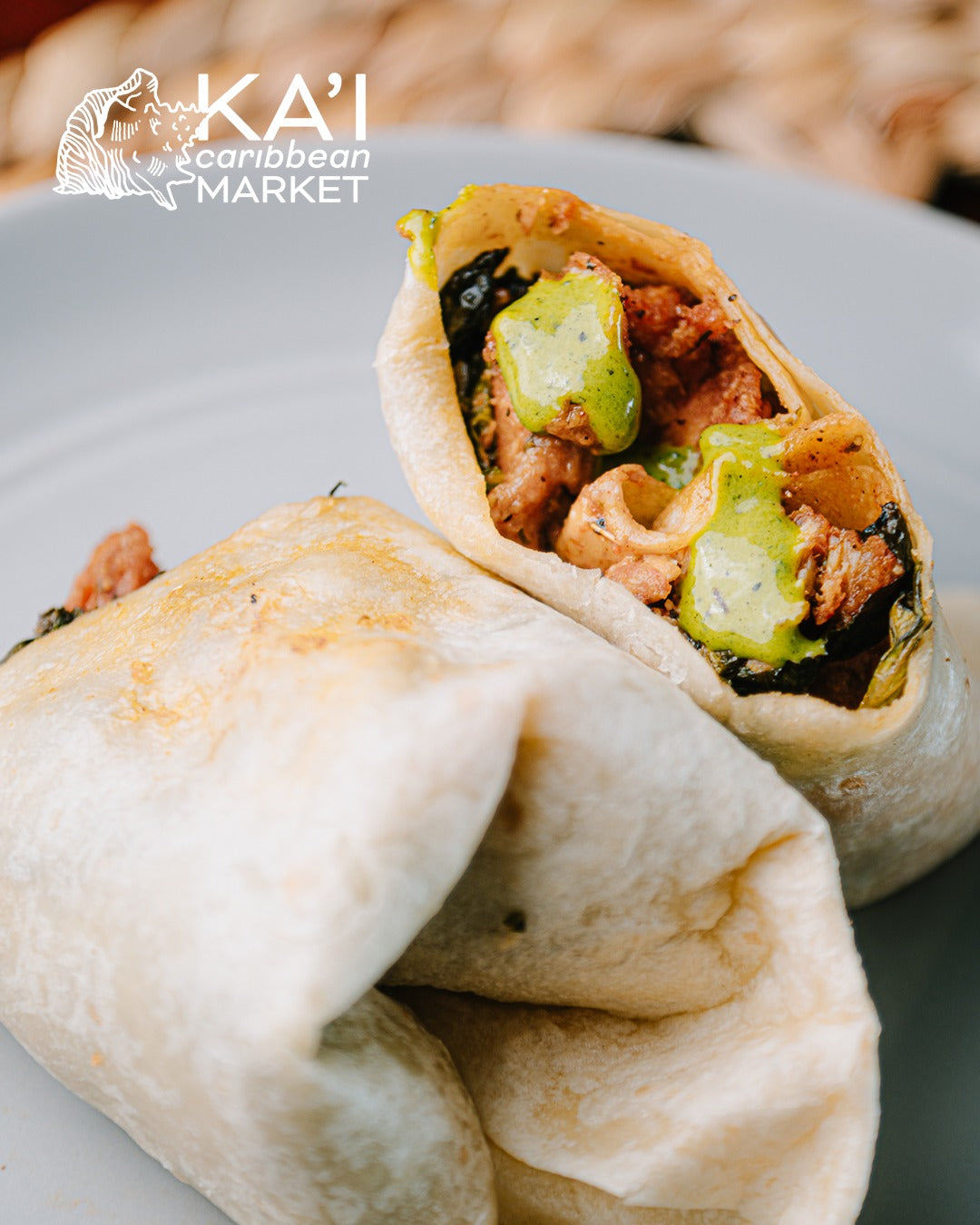 Kai Caribbean Market burrito wrap topped with green avocado habanero hot sauce on a plate